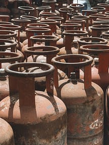 pexels-photo-29848733-29848733 Rusty gas cylinders aligned outdoors in Nepal, showcasing industrial storage.